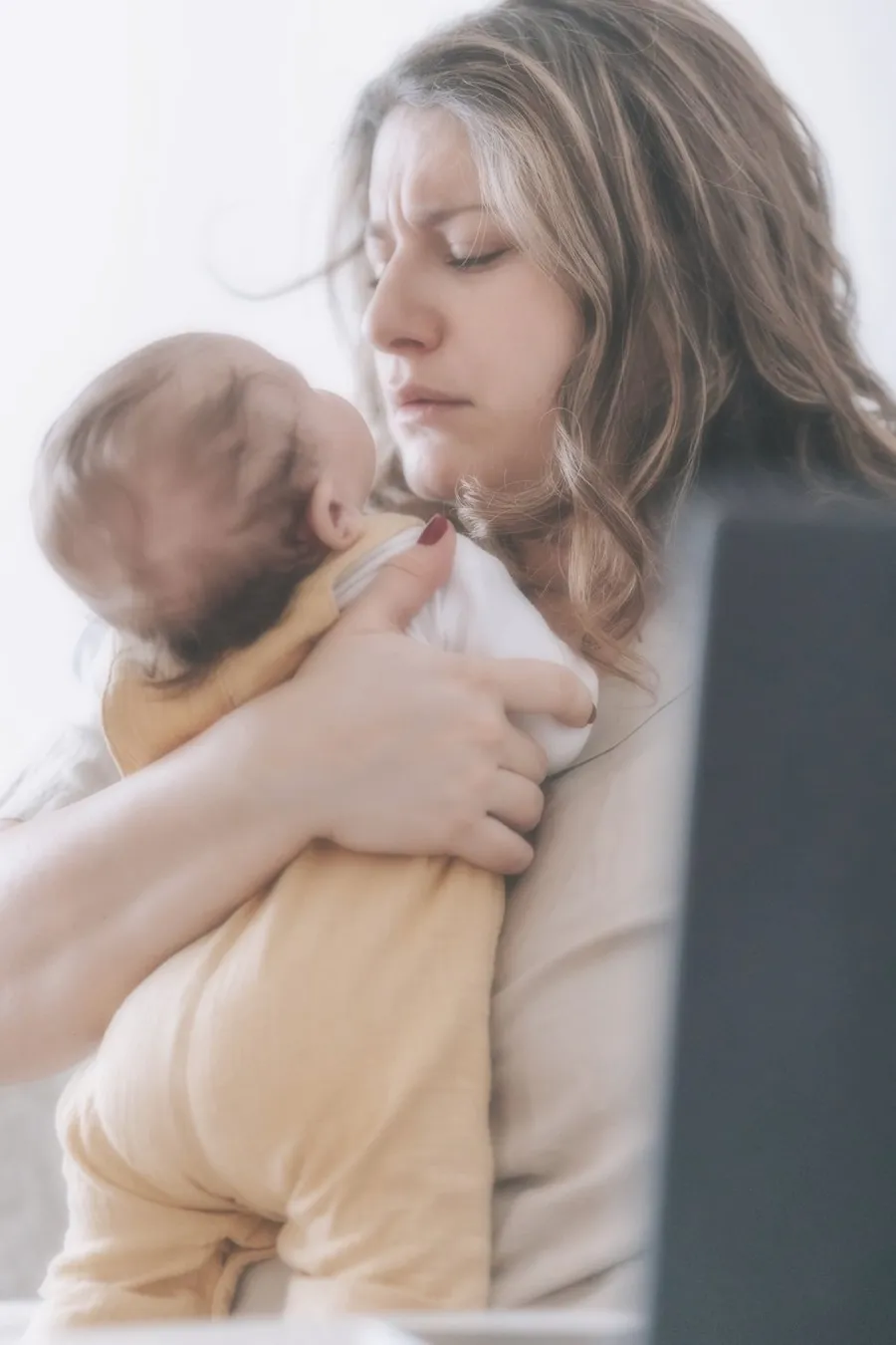 Mãe cansada com o bebé ao colo