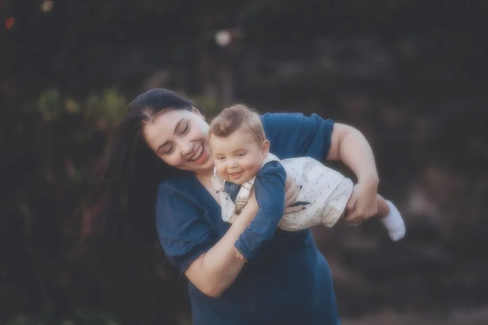 Mãe a sorrir com o bebé ao colo